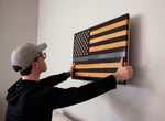 man hanging thin blue line flag